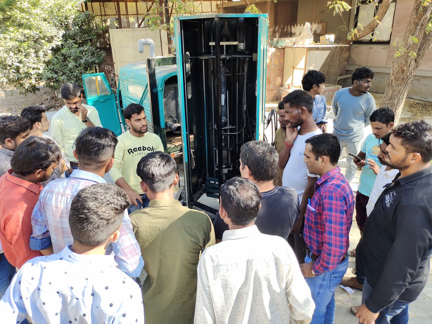 Workers gathered around a sewer-cleaning machine