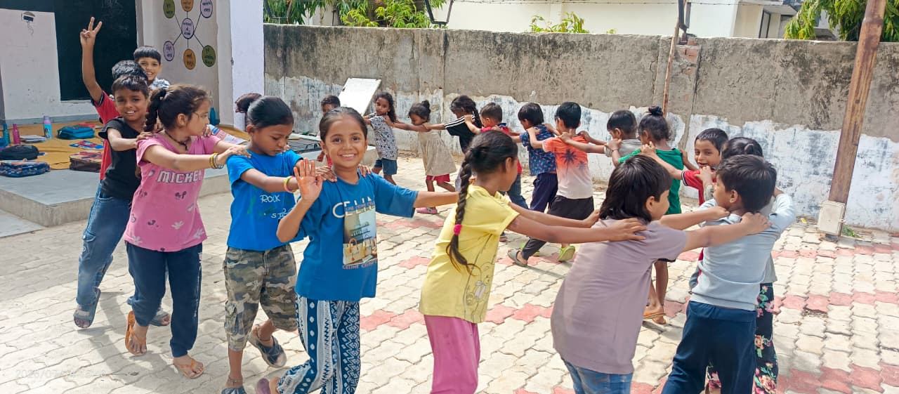 Children playing a game outside an education centre