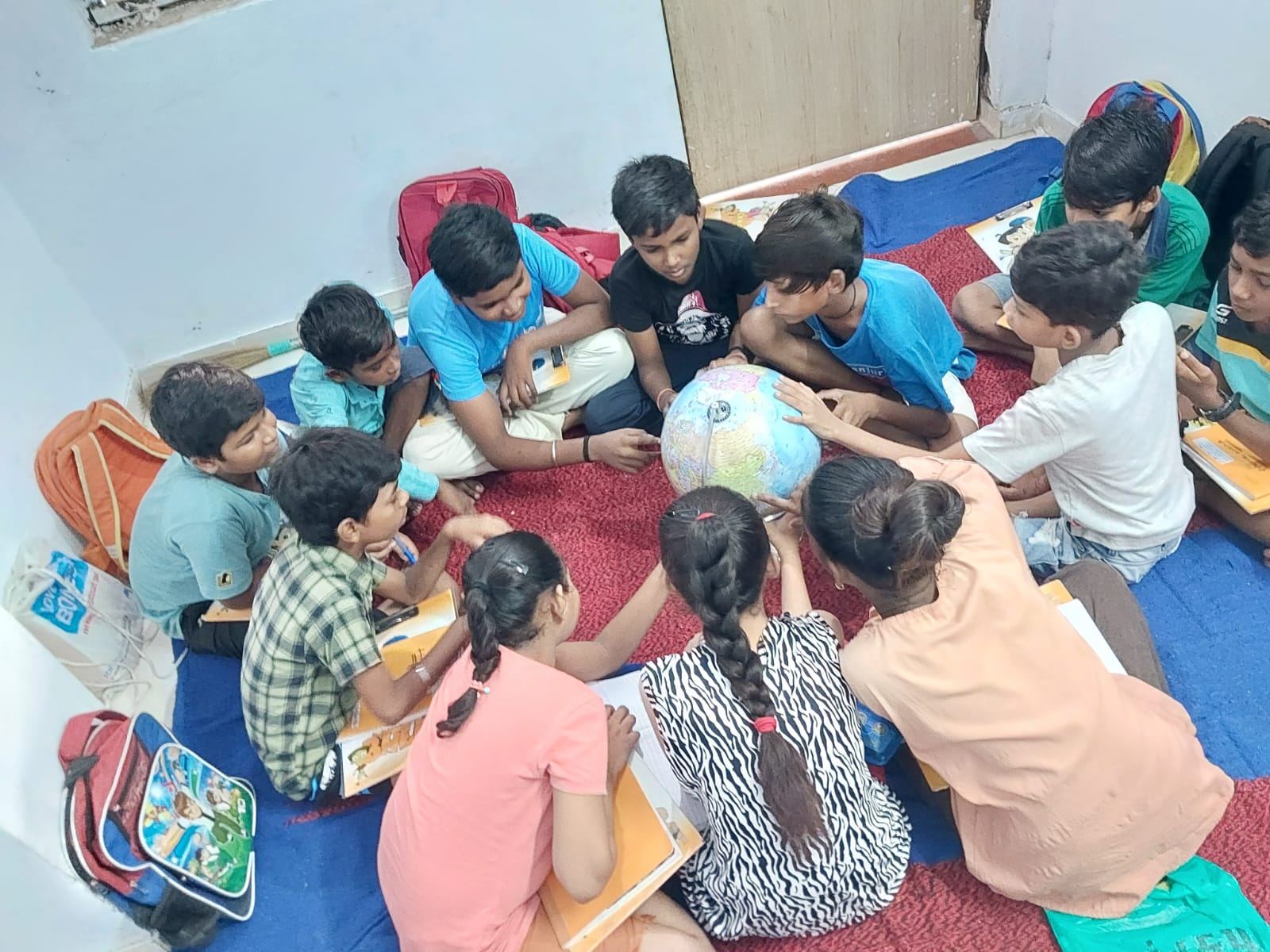 Children around a globe at a community education centre